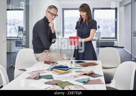 Homme d'affaires et femme d'affaires créatifs discutant des nuances au bureau Banque D'Images