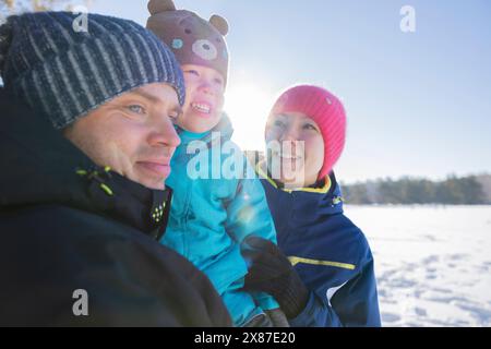 Famille heureuse jouissant ensemble dans la forêt d'hiver Banque D'Images