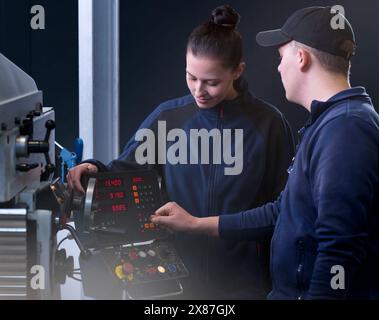 Ingénieurs utilisant la machine CNC à l'usine Banque D'Images