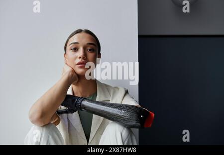 Jeune femme au bras bionique noir à la maison Banque D'Images