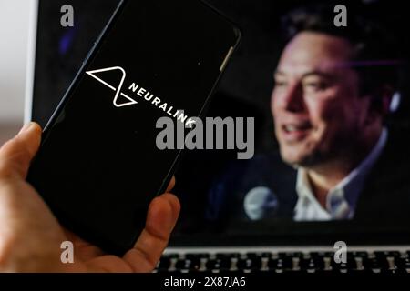 Cracovie, Pologne. 23 mai 2024. Dans cette illustration photo, le logo Neuralink est affiché sur un écran de smartphone contre un écran d'ordinateur affichant un portrait d'Elon Musk, un propriétaire de cette Startapp alors qu'Elon Musk est à la recherche de nouveaux bénévoles pour ses implants Neuralink - 23 mai 2024. (Photo de Dominika Zarzycka/Sipa USA) crédit : Sipa USA/Alamy Live News Banque D'Images