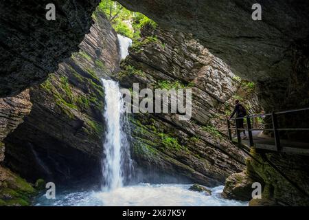 Homme sur le sentier regardant la cascade de Thur de la grotte dans la forêt Banque D'Images