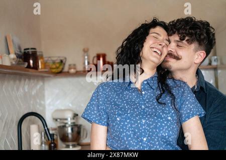 Couple romantique s'amusant dans la cuisine à la maison Banque D'Images