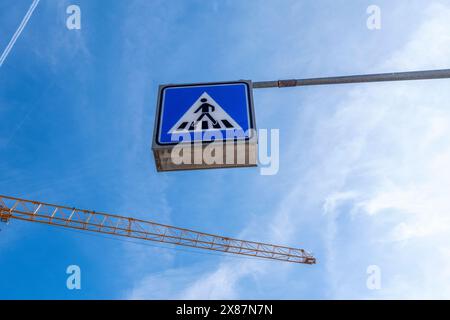 Allemagne, Bavière, Munich, vue en angle bas du panneau de passage pour piétons et grue industrielle contre le ciel Banque D'Images