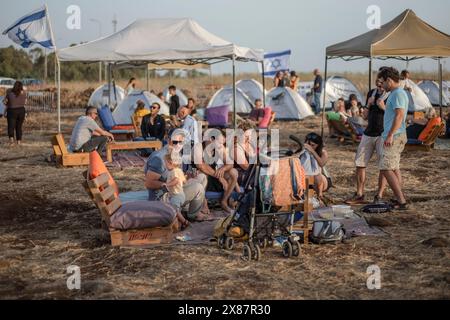 23 mai 2024, Israël, Kibboutz ami'ad : les Israéliens évacués des zones nord près de la frontière libanaise en raison des tensions transfrontalières continues, se tiennent debout au milieu de tentes lors d'un rassemblement appelant le gouvernement à les laisser rentrer chez eux. Photo : Ilia Yefimovich/dpa Banque D'Images