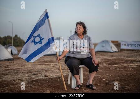 23 mai 2024, Israël, Kibboutz ami'ad : une israélienne évacuée des zones nord près de la frontière libanaise en raison des tensions transfrontalières continues, se tient au milieu de tentes lors d'un rassemblement appelant le gouvernement à les laisser rentrer chez eux. Photo : Ilia Yefimovich/dpa Banque D'Images