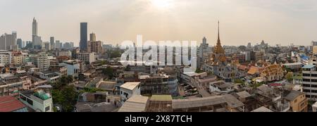 Une photo panoramique des toits des quartiers Samphanthawong, Bang Rak et Khlong San de Bangkok, avec le temple Wat Traimit Withayaram Worawihan Banque D'Images