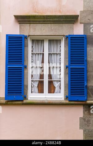 Furnas, Sao Miguel, Açores, Portugal. Fenêtre bleue à volets sur un bâtiment en stuc rose. Banque D'Images