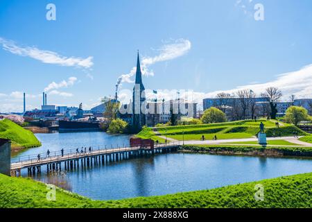 COPENHAGUE, DANEMARK - 17 AVRIL 2024 : les visiteurs traversent le pont sur les douves menant à l'entrée sud de la citatelle de Kastellet à Copenhague, Banque D'Images