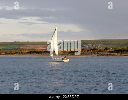La photographie montre un yacht quittant le port de Poole dans le Dorset Angleterre le soir. Banque D'Images