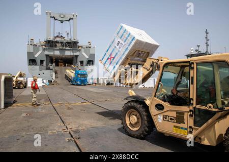 Mer Méditerranée, Israël. 20 mai 2024. Les soldats de l'armée américaine affectés à la 7e brigade expéditionnaire de transport utilisent des chariots élévateurs pour décharger l'équipement du navire de l'armée américaine LSV-5 vers l'installation de distribution Roll-on Roll-off de la jetée flottante Trident, le 20 mai 2024, à Gaza, territoire palestinien. Le quai flottant sera utilisé pour acheminer l'aide humanitaire directement des navires vers la terre pour le peuple palestinien à Gaza. Crédit : SPC. Riley Anfinson/US Army photo/Alamy Live News Banque D'Images