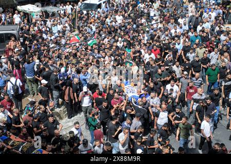 Jénine, Palestine. 23 mai 2024. Les personnes en deuil portent les corps de Palestiniens, certains sont drapés dans les drapeaux du groupe militant du Jihad islamique lors de leurs funérailles dans la ville de Djénine en Cisjordanie, le jeudi 23 mai 2024. L’armée israélienne a déclaré jeudi qu’elle avait terminé une opération de deux jours en Cisjordanie occupée qui, selon le ministère palestinien de la santé, a tué 12 Palestiniens. Des groupes militants ont revendiqué au moins huit des morts comme combattants, un du Hamas et sept de la Brigade des martyrs d'Al-Aqsa. (Photo de Nasser Ishtayeh/Sipa USA) crédit : Sipa USA/Alamy Live News Banque D'Images