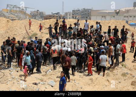 Gaza. 23 mai 2024. Les gens se bousculent pour obtenir de l’aide humanitaire larguée par un avion dans la ville de Khan Younis, dans le sud de la bande de Gaza, le 23 mai 2024. La majorité de la population de la bande de Gaza souffre d'un manque de nourriture, de médicaments et de besoins humanitaires de base depuis le début de la guerre. Les agences des Nations Unies ont mis en garde contre les conséquences désastreuses dans l'enclave, notamment la famine et la propagation des épidémies et des maladies parmi la population locale. Crédit : Rizek Abdeljawad/Xinhua/Alamy Live News Banque D'Images