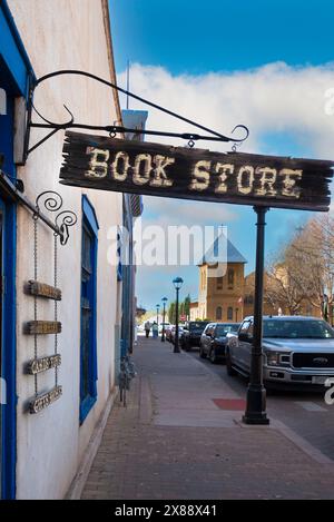 Un bâtiment historique et librairie bien-aimée sur la Plaza, Bowlins Mesilla Book Center, avec panneau en bois accroché à l'entrée du trottoir à Mesilla, NM, États-Unis Banque D'Images