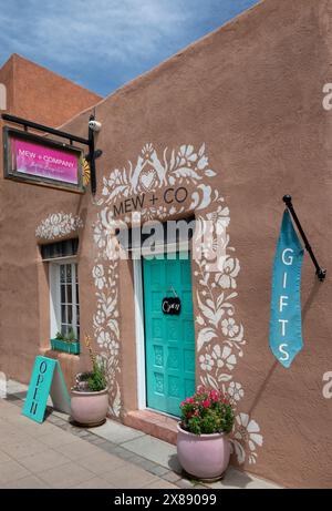 Charmante petite boutique avec des fleurs au pochoir sur le bâtiment adobe avec des accents turquoise dans la culture du Nouveau-Mexique dans le centre-ville de Las Cruces, États-Unis Banque D'Images