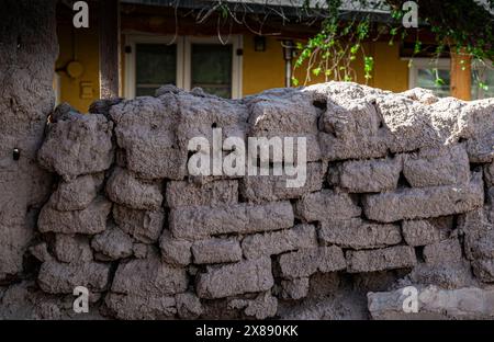 Un mur de briques en adobe fait maison pas terriblement bien construit, montrant les bases rugueuses de l'installation de briques en adobe dans le sud du Nouveau-Mexique Banque D'Images