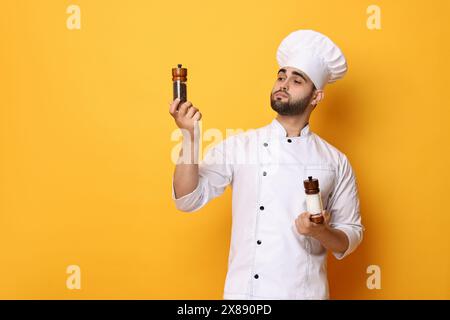 Chef professionnel avec shakers sur fond jaune. Espace pour le texte Banque D'Images