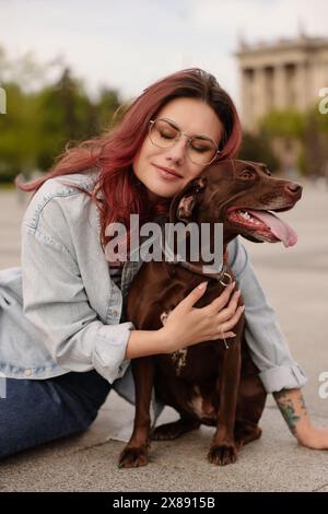 Femme avec son chien pointeur allemand mignon à poil court à l'extérieur Banque D'Images