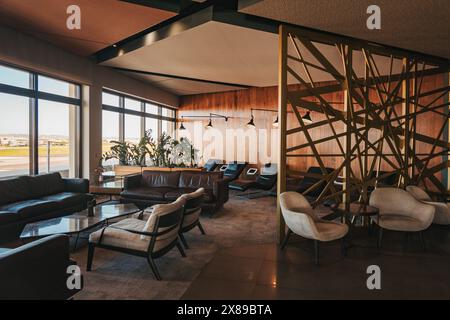 Le salon la Valette Club de l'aéroport international de Malte présente un intérieur moderne avec vue panoramique sur la piste et des éléments décoratifs en bois Banque D'Images