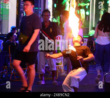 La vie quotidienne à Ho Chi Minh ville, qui s'appelait Saigon, au Vietnam, en Asie. Vie nocturne sur Walking Street Saigon, également appelé Bui Vien Street, la rue principale de la soi-disant «zone des routards» de Ho Chi Minh ville. Un jeune homme ou un adolescent jette une flamme de sa bouche, mange du feu ou respire le feu, pour solliciter des conseils des visiteurs. Les jeunes utilisent du kérosène pour faire des flammes et peuvent brûler la bouche ou avaler du kérosène ou de la paraffine. Banque D'Images