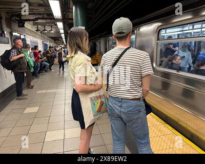 Les navetteurs de la station 77th Street, dans la section Upper East Side de Manhattan à New York, attendent que leur train arrive à la gare. Banque D'Images