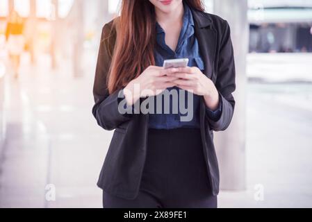 Femme asiatique utilisant ipad shopping site en ligne sur smartphone avec le visage souriant. Bonheur femme asiatique tenant le téléphone portable vérifiant le courrier de la boutique en ligne Banque D'Images