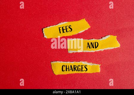 Frais et charges mots écrits sur des morceaux de papier jaune déchiré avec fond rouge. Symbole des frais et frais conceptuels. Banque D'Images