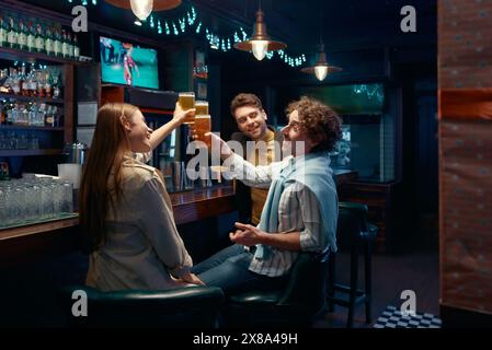 Amis employé célébrant tout en se réunissant pour se reposer après le travail dans le bar Banque D'Images