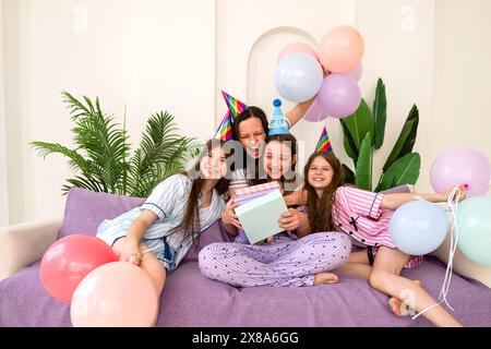 Famille riant et embrassant lors d'une joyeuse fête d'anniversaire à la maison. Moments importants, mettant en valeur l’ambiance festive et familiale. Banque D'Images