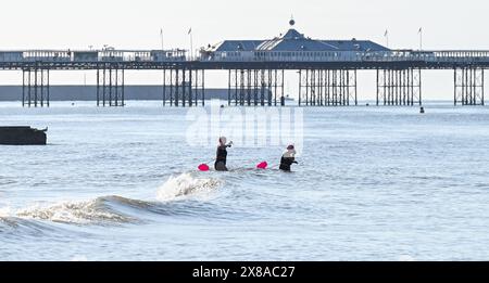 Brighton UK 24 mai 2024 - les nageurs tôt le matin à Brighton se dirigent dans la mer comme ils apprécient le temps chaud et ensoleillé le long de la côte sud avec plus de prévisions de soleil pour le week-end de vacances : crédit Simon Dack / Alamy Live News Banque D'Images