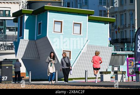 Brighton UK 24 mai 2024 - les coureurs et les marcheurs passent par la maison à l'envers sur le front de mer de Brighton par une belle matinée ensoleillée avec plus de bonnes prévisions météorologiques pour le week-end de vacances : crédit Simon Dack / Alamy Live News Banque D'Images