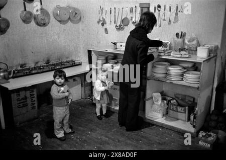 Chiswick Women's Aid. Une mère dans la cuisine communautaire avec deux enfants. La communauté offrait un environnement où les femmes vivant dans des circonstances semblables pouvaient apporter un soutien affectif et moral ainsi que de l'amitié. Richmond, Londres, Angleterre vers novembre 1975.1970s Royaume-Uni HOMER SYKES Banque D'Images