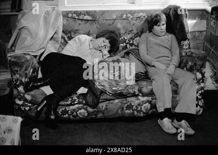 Chiswick Women's Aid, Un moment calme pendant le premier Noël que le refuge était situé dans l'ancien Palm court Hôtel. Une mère épuisée endormie sur un canapé, son fils regarde la télévision. Londres, EnglandDecember 1975 1970s UK HOMER SYKES Banque D'Images