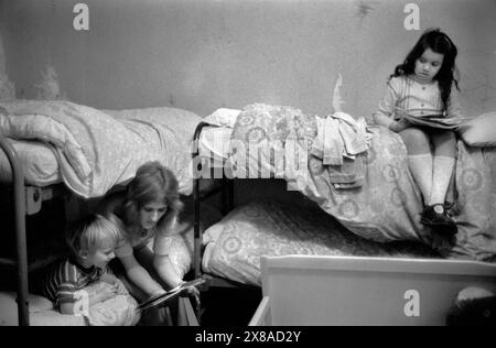 Chiswick Women's Aid 1970s Royaume-Uni. Maintenant connu sous le nom de refuge. Une mère lit une histoire à ses enfants au coucher. C'était leur premier Noël loin de la maison familiale. Londres, Angleterre décembre 1975. HOMER SYKES Banque D'Images