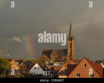 Église du village en face du ciel nuageux avec arc-en-ciel en arrière-plan, belle promenade sur le Rhin avec une tour, des lanternes et des arbres, printemps sur le Banque D'Images