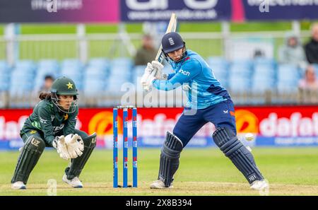 Charlie Dean battant pour l'Angleterre regardé par la gardienne Najiha Alvi dans un match international d'une journée entre l'Angleterre et le Pakistan Banque D'Images