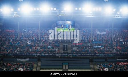 Match du championnat de football, écran du tableau d'affichage indiquant la répétition de l'objectif. Foule de fans acclamant, criant, s'amusant. Concept de publicité télévisée Sport Channel. Banque D'Images