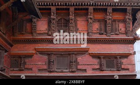 Fenêtres sculptées et statues de divinités hindoues sur le palais de neuf étages, Katmandou Durbar Square, Katmandou, Népal. Banque D'Images