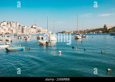 Petits bateaux ancrés dans le port de Sliema par une journée ensoleillée calme à Malte Banque D'Images