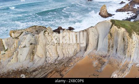 Vue aérienne de Portio Beach, falaises blanches distinctives en couches de roche et l'océan Atlantique orageux. Costa Quebrada, Cantabrie, Espagne Banque D'Images