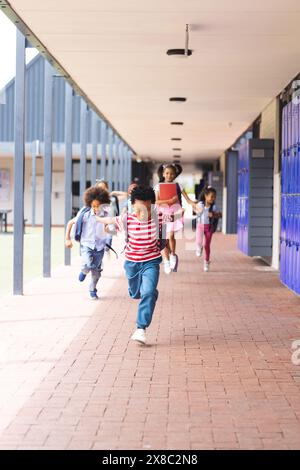 À l'école, des enfants divers courent dans le couloir avec un espace de copie à l'extérieur Banque D'Images