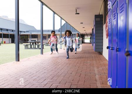 À l'école, divers enfants courent dans le couloir avec un espace de copie à l'extérieur Banque D'Images