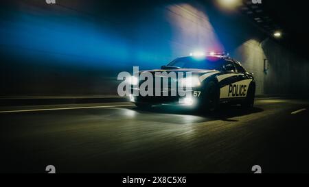 Voiture de patrouille de la circulation à la poursuite, conduite rapide avec sirènes flamboyantes dans les rues de la ville. Des officiers de la loi poursuivent un suspect. Les flics dans Squad car réagissent à l'appel d'urgence. Prise de vue nocturne cinématographique Banque D'Images