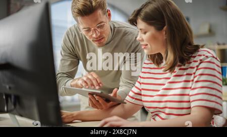 Portrait de deux jeunes collègues créatifs consultant directement à l'aide d'un ordinateur et d'une tablette. Un superviseur blanc discute de la planification avec une femme caucasienne responsable des opérations. Gros plan. Banque D'Images