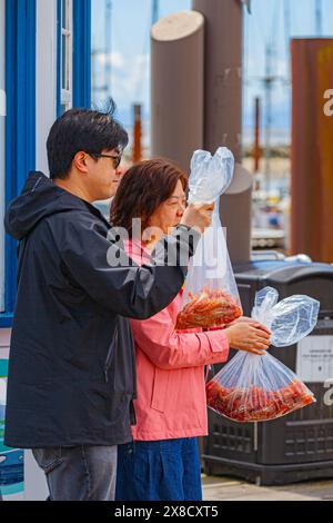 Mère et fils posant avec leurs sacs de crevettes Spot au quai Fishermans à Steveston Canada Banque D'Images