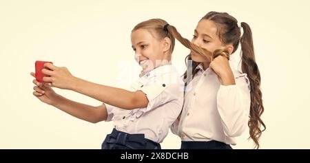 amis d'école bloguant et prenant selfie avec le téléphone dans la classe. Banque D'Images