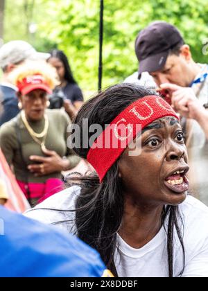 New York, New York, États-Unis. 23 mai 2024. Une femme contre Trump crie à la foule ce qu’elle pense de lui. En dehors d’un rassemblement de Donald Trump dans le Bronx, New York, alors qu’un permis a été délivré pour 3 500 personnes, différents points de vente estiment la fréquentation allant de 4 000 à 35.000, déclenchant des conversations en raison de l’écart. En dehors de l'événement étiqueté se trouvaient des personnages des deux côtés, y compris des manifestants. (Crédit image : © Carlos Chiossone/ZUMA Press Wire) USAGE ÉDITORIAL SEULEMENT! Non destiné à UN USAGE commercial ! Banque D'Images