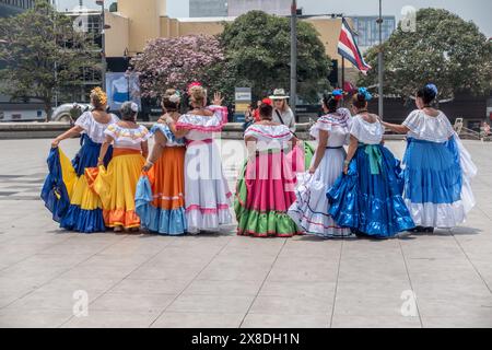 Des femmes âgées dans des robes traditionnelles costariciennes avec le dos tourné parlent à une femme à San José, Costa Rica. Banque D'Images