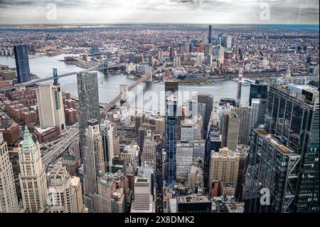 Admirez l'étalement impressionnant des gratte-ciels de Manhattan depuis un point de vue audacieux en contrebas. Des géants imposants traversent les nuages, offrant une vue unique. Banque D'Images