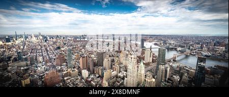 Admirez l'étalement impressionnant des gratte-ciels de Manhattan depuis un point de vue audacieux en contrebas. Des géants imposants traversent les nuages, offrant une vue unique. Banque D'Images